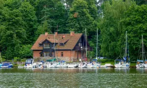 Port w Rucianem Nidzie, z ceglanym budynkiem i żaglówkami, to jedna z głównych atrakcji tego malowniczego miejsca.