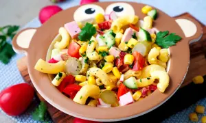 Bunter Nudelsalat mit Mais, Tomaten und Gurken in einem Affen-Teller – perfekt für Kinder!