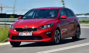Czerwony Kia Ceed 1.4 benzyna w ruchu drogowym. Elegancki design i dynamiczna jazda.
