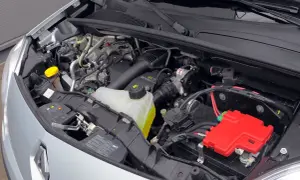 Silnik Renault Kangoo 2 z widocznym zbiorniczkiem płynu chłodniczego, akumulatorem i czerwonymi osłonami.