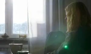 En person sitter ensam vid ett fönster med en kopp kaffe. Kanske en stund av reflektion kring att sluta dricka alkohol och hantera depression.