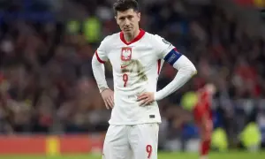 Robert Lewandowski w białej koszulce reprezentacji Polski, z numerem 9 na piersi i spodenkach.