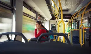Kobieta w czerwonej bluzce podróżuje autobusem, zastanawiając się, czy Bułgaria jest bezpieczna.