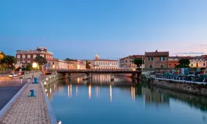 Canale di Senigallia al tramonto, con riflessi sull'acqua e palazzi storici. La fiera senigallia è un evento che anima questa splendida città.