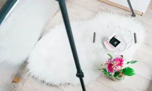 Zdjęcia flat lay: białe futrzane dywaniki, koszyk z biżuterią i bukiet kwiatów.