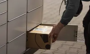 Osoba wkłada paczkę do paczkomatu InPost.