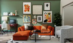 Gemütliches Wohnzimmer mit orangefarbenem Sofa, vielen Bildern an der grünen Wand und einem Schreibtisch. Perfekt, um nach dem **wand streichen** zu entspannen.