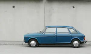 Blå Austin Maxi parkerad vid en betongvägg. En klassisk bil som väcker minnen.