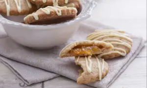 Galletas de espelta rellenas de mermelada, cubiertas con glaseado blanco.