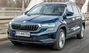 Niebieski Skoda Karoq w ruchu, z kierowcą za kierownicą. Sprawdź aktualną skoda karoq cena.