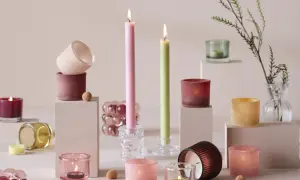 En samling av stearinljus i olika former och färger, från höga smala till små värmeljus, skapar en mysig atmosfär.