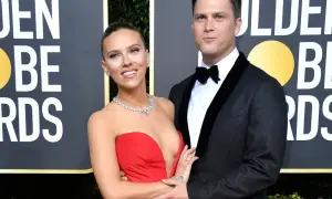 Scarlett Johansson w czerwonej sukni i Colin Jost w garniturze na ściance Golden Globe Awards.