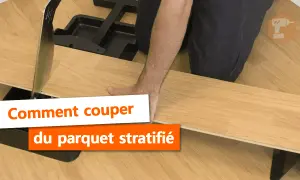 Un homme utilise un outil pour la découpe de parquet stratifié.
