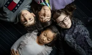 Fyra barn ligger tätt ihop. En 8-åring har svårt att somna, medan de andra verkar sova.
