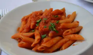 En tallrik med penne arrabiata, en kryddig tomatsås som betyder "arg" på italienska. Garnerad med färsk persilja.