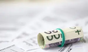 Zrolowane banknoty na dokumentach podatkowych. Przygotowanie do rozliczenia ulgi rehabilitacyjnej 2026.