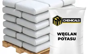 Stos białych worków z napisem "WĘGLAN POTASU" na drewnianej palecie.