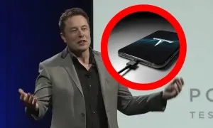 Elon Musk prezentuje telefon z logo Tesli, podłączony do ładowania.