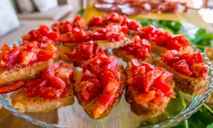 Pyszne bruschetta z pomidorami, czosnkiem i bazylią na chrupiących grzankach. Idealna przekąska na letnie przyjęcie.
