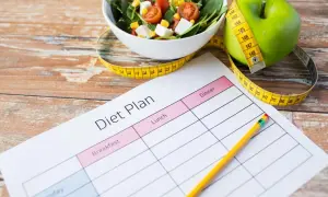 Piano alimentare con mela verde, insalata e metro, per una dieta facile da seguire.