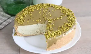 Una deliziosa cheesecake al pistacchio, con una copertura cremosa e granella di pistacchi croccanti, pronta per essere gustata.