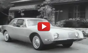 En Studebaker Avanti glider framför ett hus.
