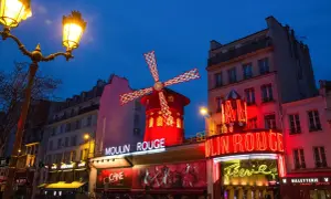 Le Moulin Rouge illuminé la nuit. La durée du spectacle est une question que beaucoup se posent avant de venir admirer ce lieu emblématique.