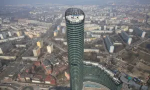 Widok z lotu ptaka na Sky Tower we Wrocławiu, otoczony blokami mieszkalnymi i miejskim krajobrazem.