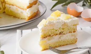 Ein saftiges Stück Ananas Torte mit Sahne und Ananasstücken, bereit zum Genießen.