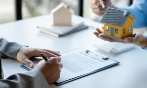 Firma di un contratto di comodato d'uso oneroso con una casa modello in mano.