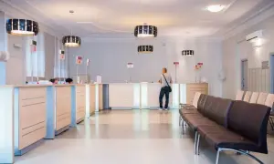 Recepcja w nowoczesnej klinice medycznej z poczekalnią i systemem kolejkowym.