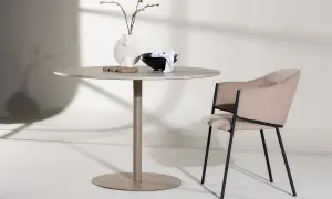 Runt matbord inspiration med en modern stol. En vas med kvistar och skålar på bordet.