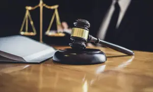 Młotek sędziowski, waga sprawiedliwości i księga symbolizują sprawiedliwy proces, np. przepisanie majątku na żonę.