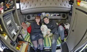 Un couple et leur chien blanc profitent d'un moment de détente dans l'espace cosy de leur camion américain.
