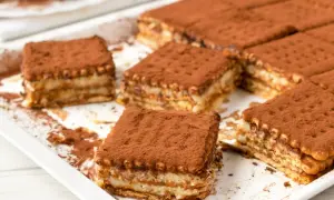 Pyszne, tanie ciasto bez pieczenia z herbatnikami, posypane kakao. Idealne na deser!