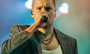 Krzysztof Zalewski śpiewa "Annuszka", w szarym garniturze i z łańcuchami na szyi.