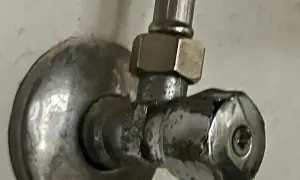 Metalowy zawór wody z uchwytem i śrubą.