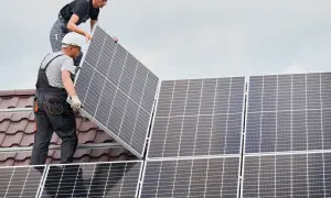 Instaladores colocan placas solares en un tejado, asegurando el anclaje para la energía limpia.