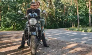Para z uśmiechem na twarzy, podróżująca motocyklem po malowniczych Kaszubach.