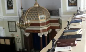 Wnętrze synagogi z księgami na balustradzie. Poznaj zasady ubioru i etykiety, jak zachować się w meczecie i synagodze.