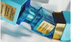 Błękitne pudełko i szklana butelka perfum Tom Ford Mandarino di Amalfi, emanujące świeżością włoskiego wybrzeża.