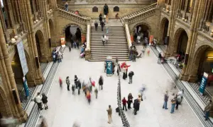 Besökare rör sig genom ett stort, arkitektoniskt imponerande museum i London.