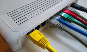 Router z wieloma kolorowymi kablami Ethernet, gotowy do połączenia z siecią PPPoE.