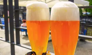 Due bicchieri di hefeweizen birra dorata con schiuma bianca e soffice, pronti per essere gustati all'aperto.