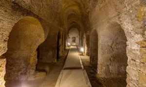 Corridoio sotterraneo scavato nella roccia a Camerano, Ancona, con illuminazione soffusa che crea un'atmosfera suggestiva.