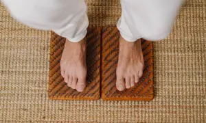 Voeten staan op spijkermat, een oefening voor balans en ontspanning.