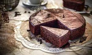 Ein saftiger Schokoladenkuchen mit glänzender Glasur, ein Stück wurde bereits entnommen. Dieses schokoladenkuchen rezept saftig ist ein Traum!