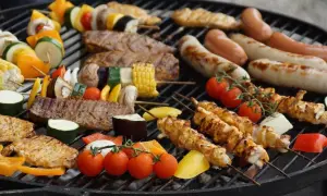 Grill z kiełbaskami, szaszłykami z kurczaka i warzywami, mięsem i kukurydzą.