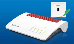 Biały router FRITZ!Box z czerwonymi wstawkami i diodami LED, obok gniazdka Fiber z podłączonym kablem światłowodowym.