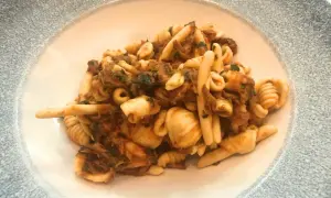 Un piatto invitante di trofie alla carlofortina, con pasta fresca e un ricco sugo di pesce.
